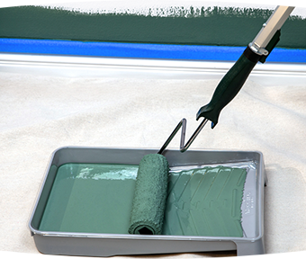 Rolling a paint roller into a tray of paint