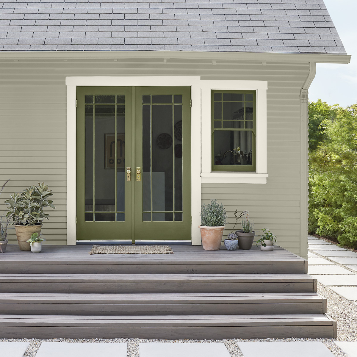 A green house exterior and door painted with Behr Dynasty Exterior paint